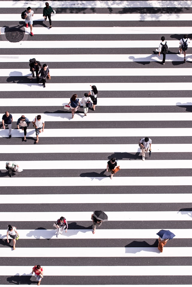 An overhead view of a busy pedestrian crossing, dozens of people walking in every direction at once
